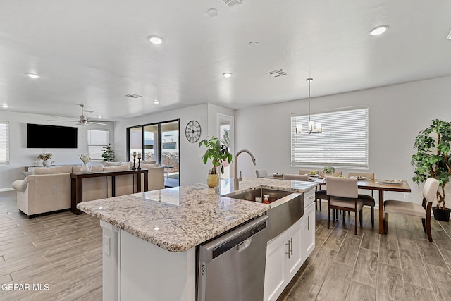kitchen with visible vents, dishwasher, a sink, light wood-style floors, and an island with sink