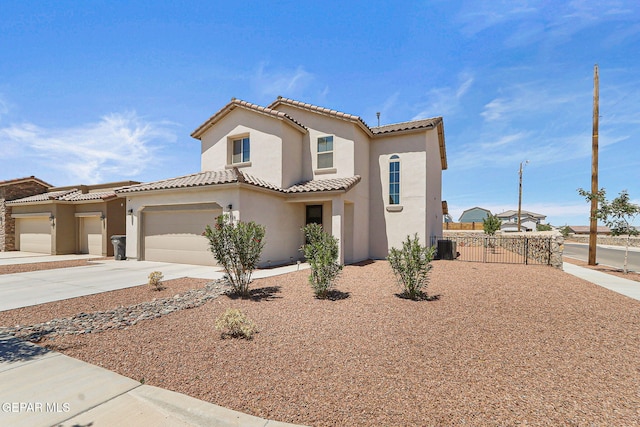 mediterranean / spanish home with a garage, fence, stucco siding, concrete driveway, and a tile roof