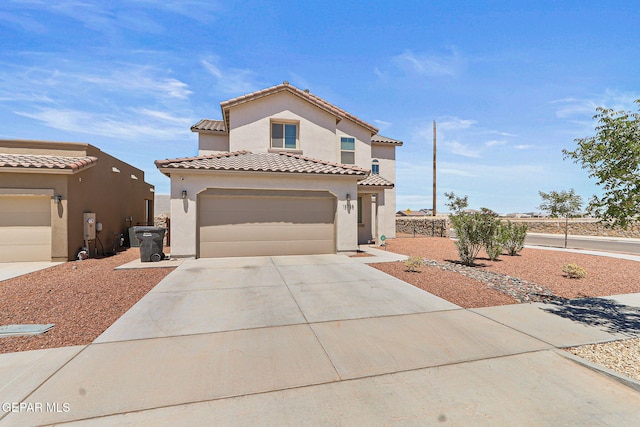 mediterranean / spanish house featuring concrete driveway, a tiled roof, and stucco siding
