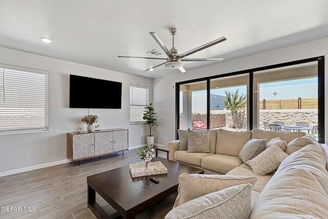living area featuring baseboards, ceiling fan, recessed lighting, and wood finished floors