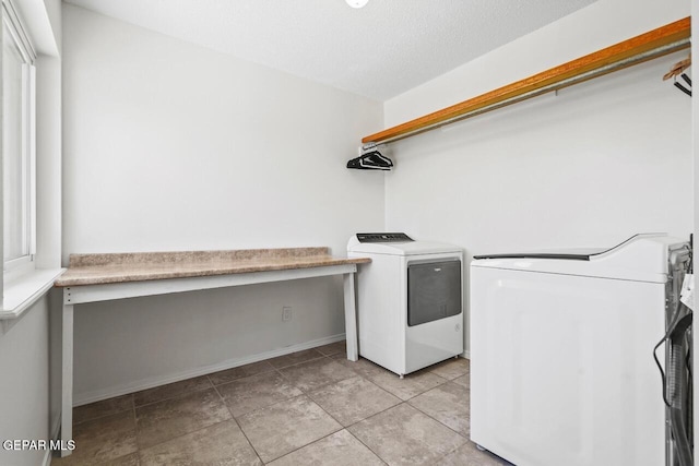 laundry room with a desk, washer and clothes dryer, baseboards, and light tile patterned floors