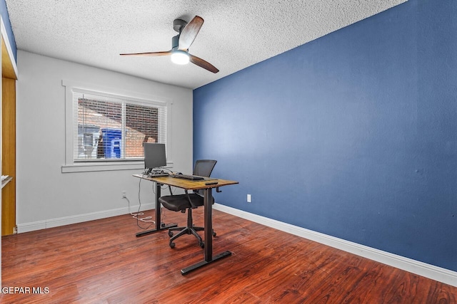 unfurnished office with a ceiling fan, a textured ceiling, wood finished floors, and baseboards