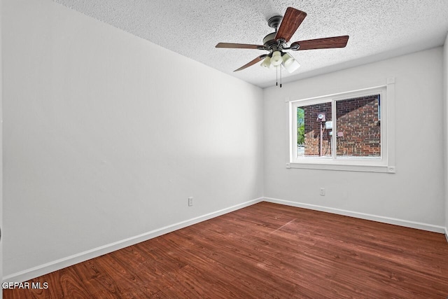 unfurnished room featuring dark wood finished floors, a textured ceiling, baseboards, and ceiling fan