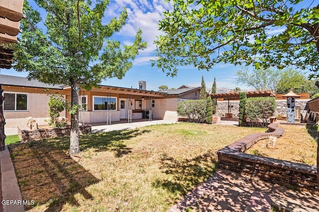 back of house featuring a patio area, brick siding, and a lawn