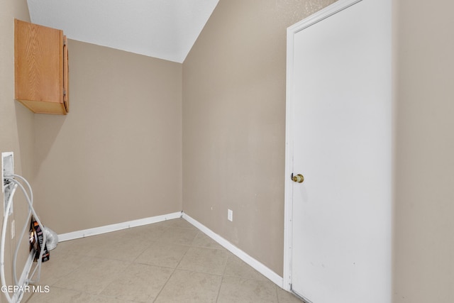 washroom with light tile patterned floors, baseboards, hookup for a washing machine, and cabinet space