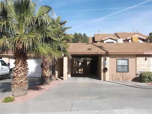 view of front of house with brick siding, driveway, and an attached carport