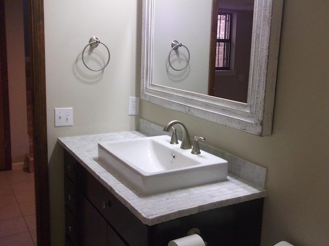 half bathroom with vanity and tile patterned floors