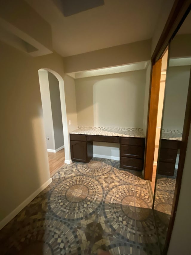 interior space featuring baseboards and arched walkways