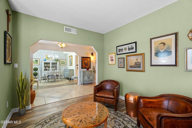 1829 Paseo Real Cir, El Paso, TX 79936 - sitting room with arched walkways, baseboards, wood finished floors, and visible vents