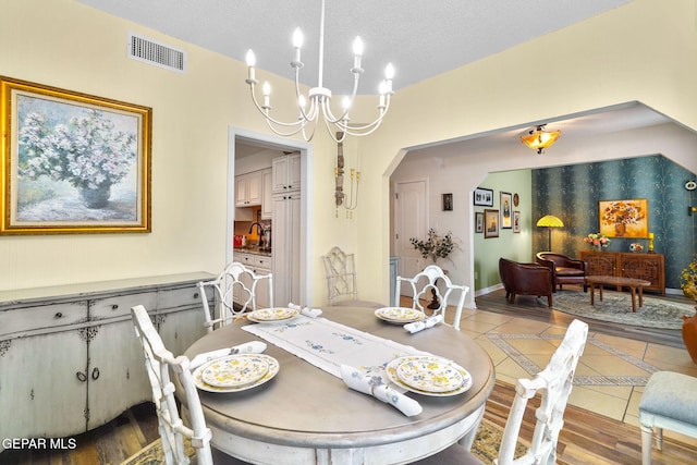 1829 Paseo Real Cir, El Paso, TX 79936 - dining area with visible vents, tile patterned flooring, a textured ceiling, arched walkways, and a notable chandelier