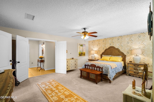 1829 Paseo Real Cir, El Paso, TX 79936 - bedroom featuring ceiling fan, light colored carpet, a textured ceiling, baseboards, and visible vents