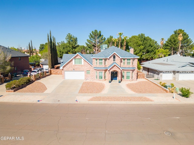 1829 Paseo Real Cir, El Paso, TX 79936 - view of front of home with driveway, a chimney, brick siding, fence, and an attached garage