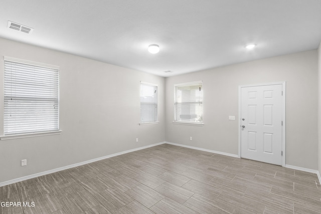 spare room featuring baseboards and visible vents