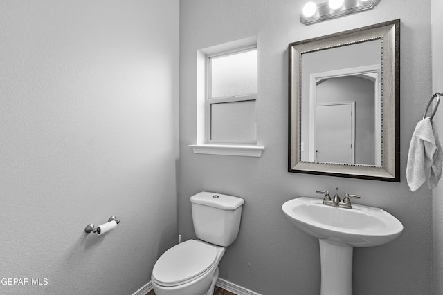 half bath with toilet and a sink