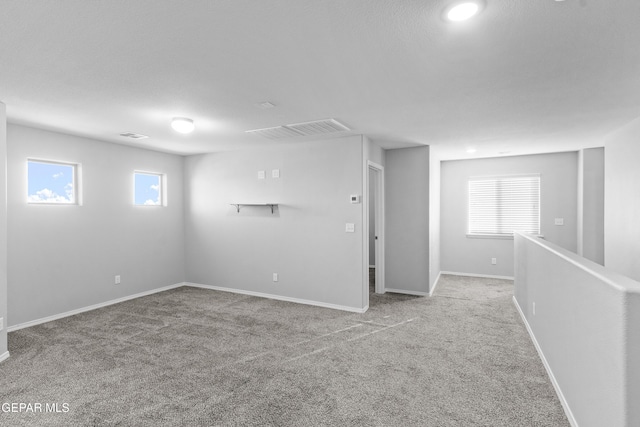 basement featuring carpet floors, baseboards, and visible vents
