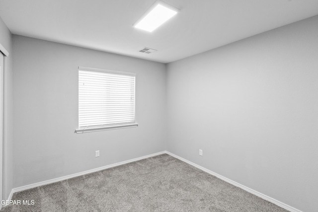 unfurnished room featuring baseboards, carpet flooring, and visible vents