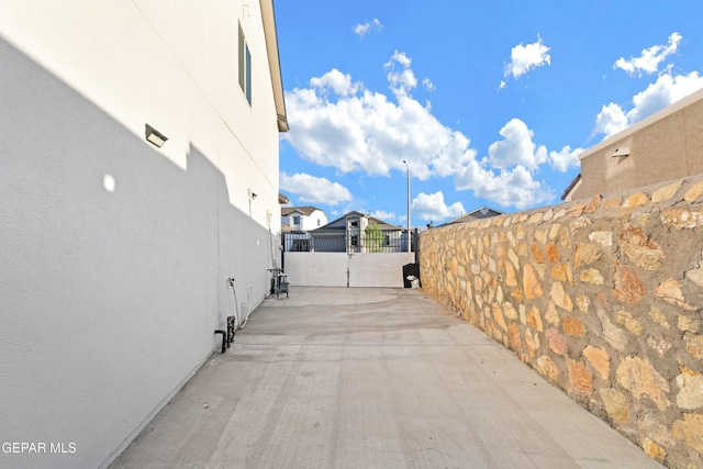 view of road with street lighting, a gate, a gated entry, driveway, and a residential view