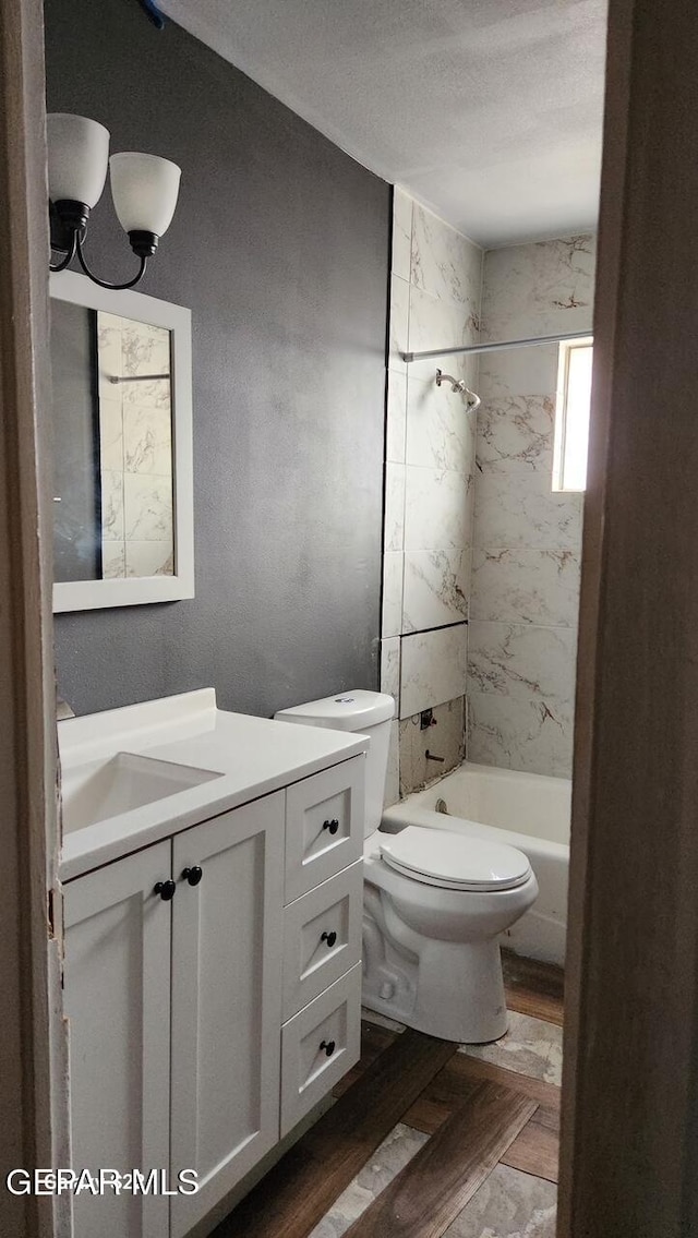 11325 Tom Ulozas Dr, El Paso, TX 79936 - bathroom with vanity, toilet, tub / shower combination, wood finished floors, and a textured ceiling