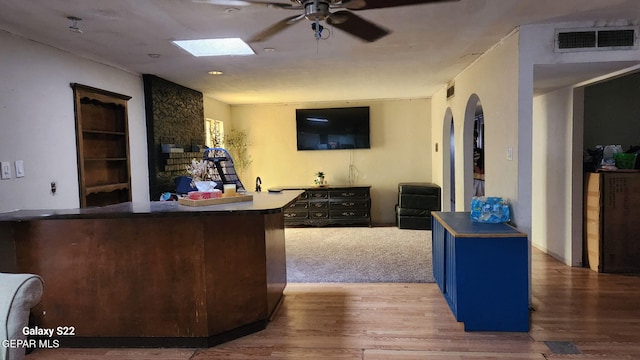 11325 Tom Ulozas Dr, El Paso, TX 79936 - bar featuring wood finished floors, a ceiling fan, arched walkways, and a large fireplace