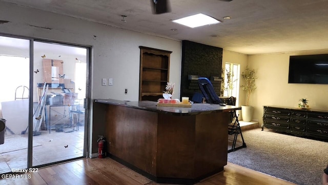 11325 Tom Ulozas Dr, El Paso, TX 79936 - kitchen featuring wood finished floors, dark countertops, and a kitchen bar
