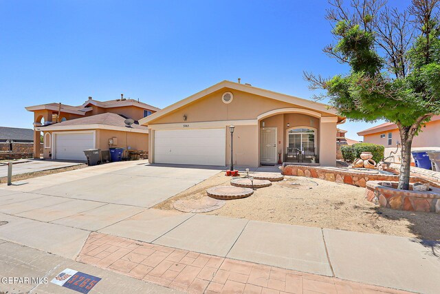 view of front facade featuring a garage, stucco siding, and driveway