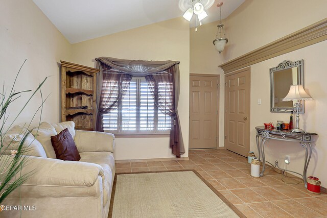 tiled living area with high vaulted ceiling, ceiling fan, and baseboards