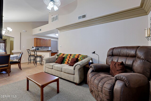 living area featuring high vaulted ceiling, visible vents, light tile patterned floors, and ceiling fan with notable chandelier