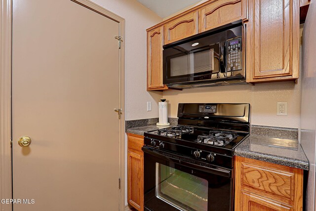 kitchen with dark countertops and black appliances