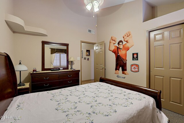 carpeted bedroom with visible vents and a towering ceiling