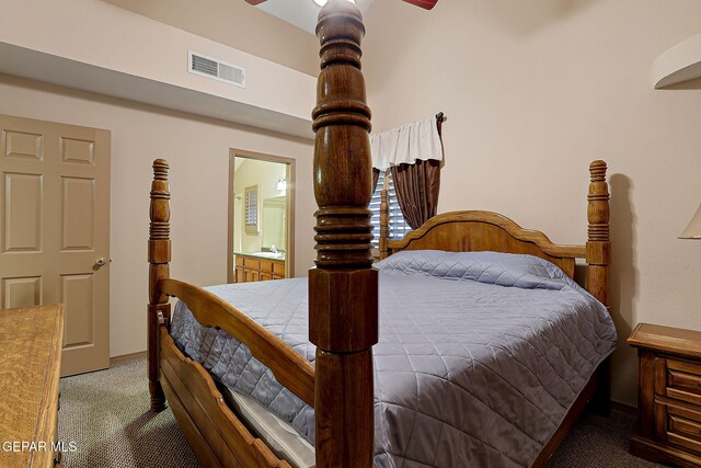 carpeted bedroom featuring baseboards, visible vents, a sink, and ensuite bathroom