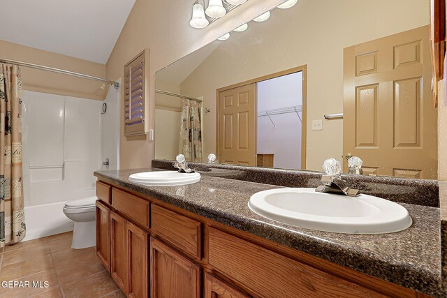 full bathroom with a sink, tile patterned floors, double vanity, and lofted ceiling