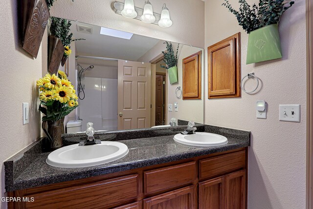 full bathroom with a sink, a shower, double vanity, and visible vents