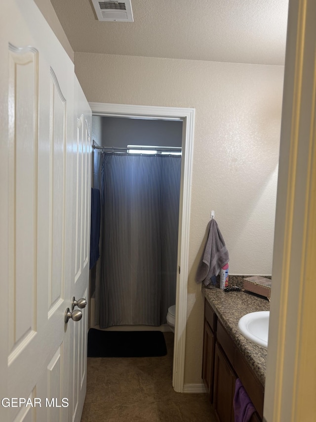 full bath featuring toilet, visible vents, a shower with shower curtain, and vanity