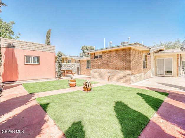 view of yard featuring a patio and an outdoor structure