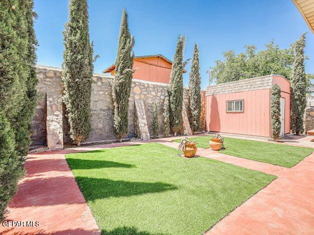 view of yard featuring a fenced backyard, an outbuilding, and a shed