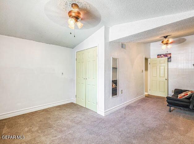 spare room featuring vaulted ceiling, baseboards, ceiling fan, and carpet flooring