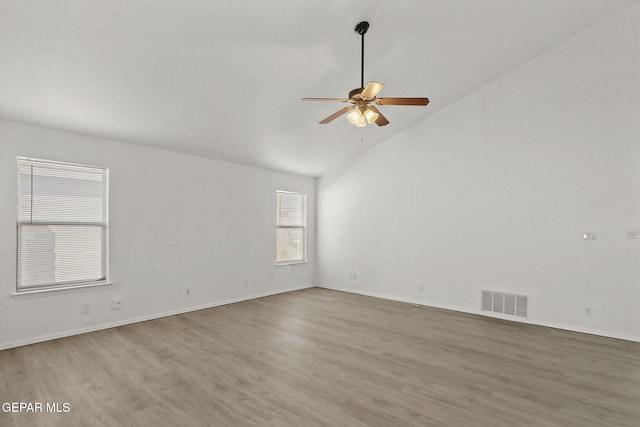 spare room featuring a ceiling fan, visible vents, wood finished floors, high vaulted ceiling, and baseboards