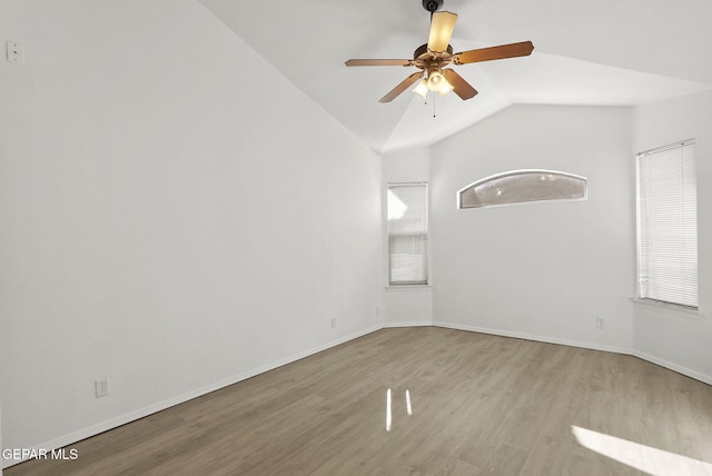 spare room featuring a ceiling fan, baseboards, vaulted ceiling, and wood finished floors
