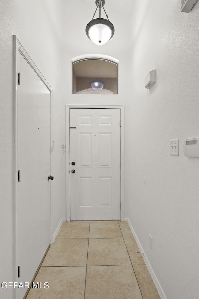 doorway to outside with baseboards and light tile patterned floors