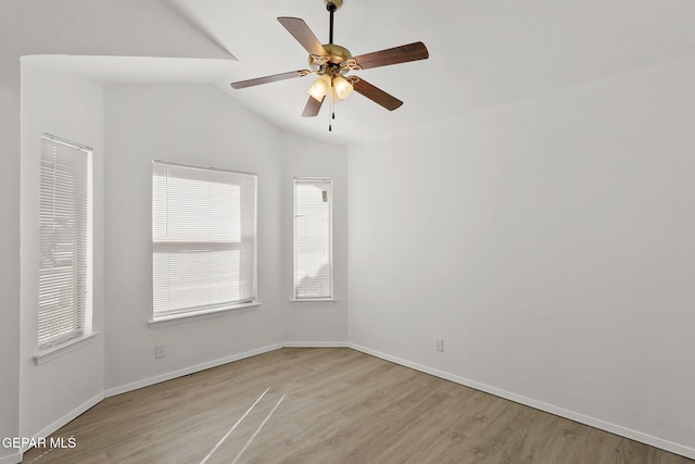 unfurnished room featuring plenty of natural light, a ceiling fan, vaulted ceiling, and wood finished floors