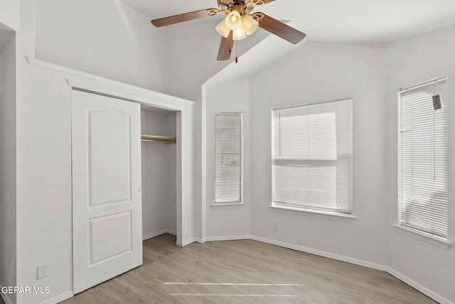 unfurnished bedroom featuring a closet, baseboards, vaulted ceiling, and light wood-style flooring