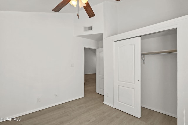 unfurnished bedroom featuring a ceiling fan, baseboards, wood finished floors, visible vents, and a closet