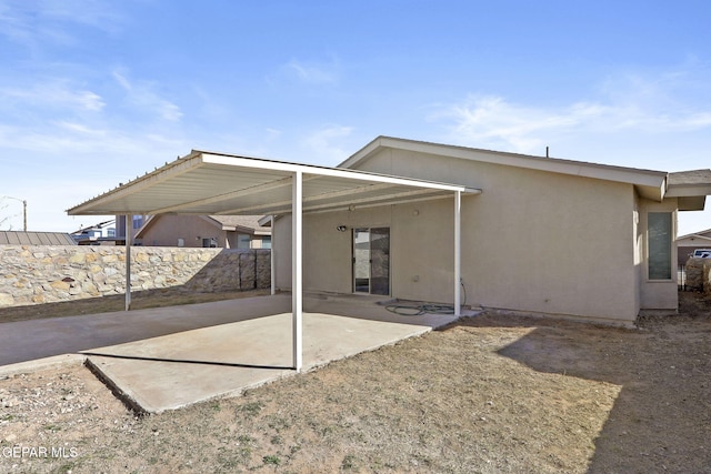 back of property with a patio, fence, and stucco siding