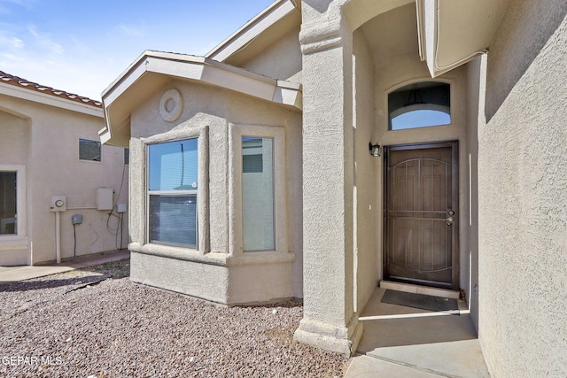 view of exterior entry featuring stucco siding