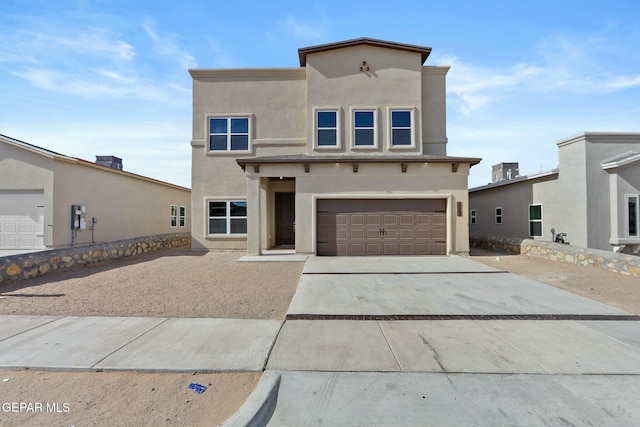 view of front facade featuring a garage, stucco siding, and driveway