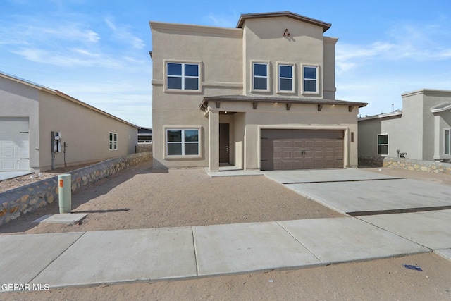 view of front of property featuring an attached garage, driveway, and stucco siding