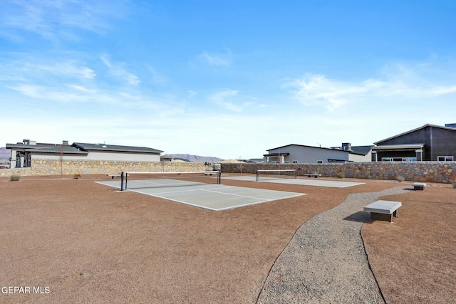 surrounding community with a tennis court and fence