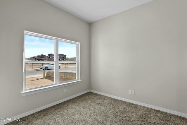 carpeted spare room featuring baseboards