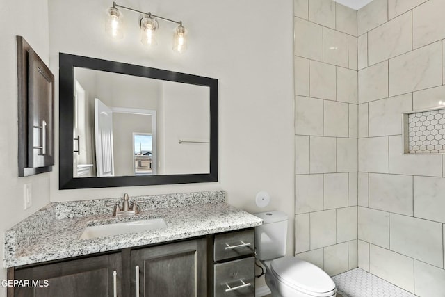 full bath with vanity, toilet, and tiled shower