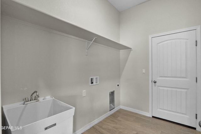 clothes washing area featuring laundry area, light wood-type flooring, a sink, baseboards, and hookup for a washing machine